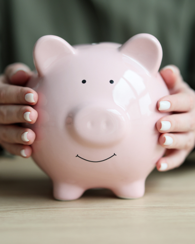 Two hands holding a pink china pig