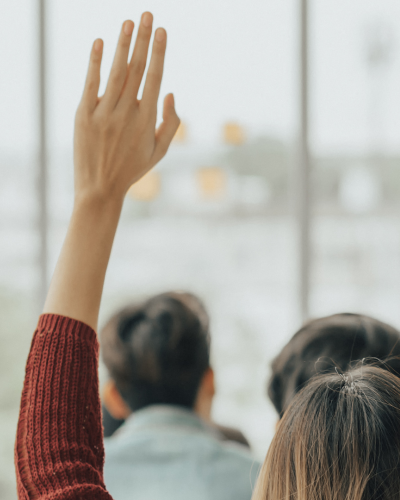 Person with their hand up in an office