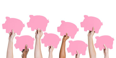 Hands holding several paper pigs