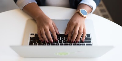 Hands typing on laptop keyboard 