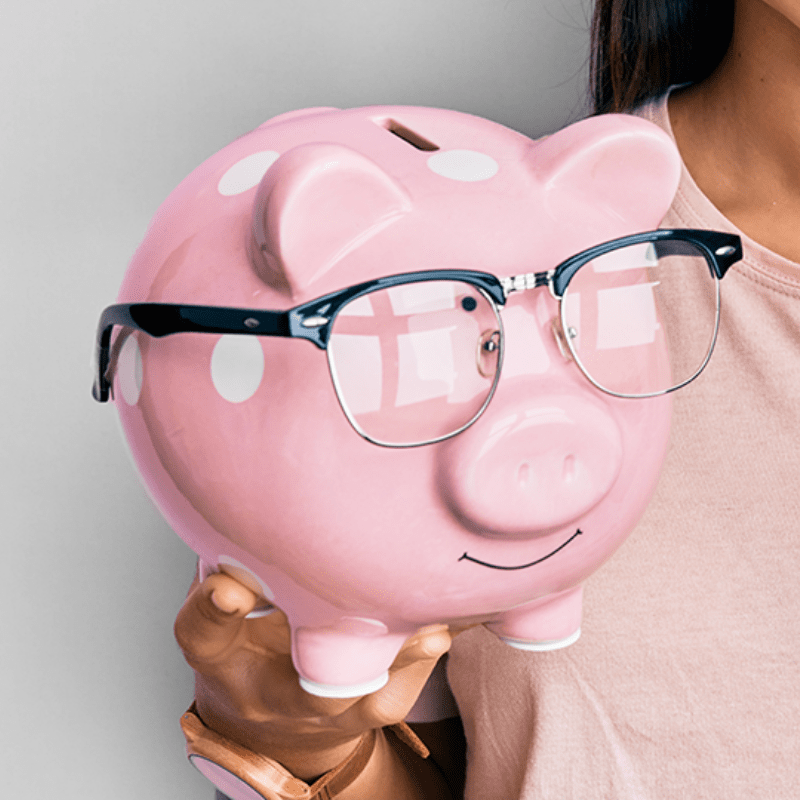 Pink piggy bank with glasses being held by a woman